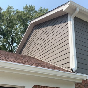HardiePlant lap siding on the side of a brown house with a sky background